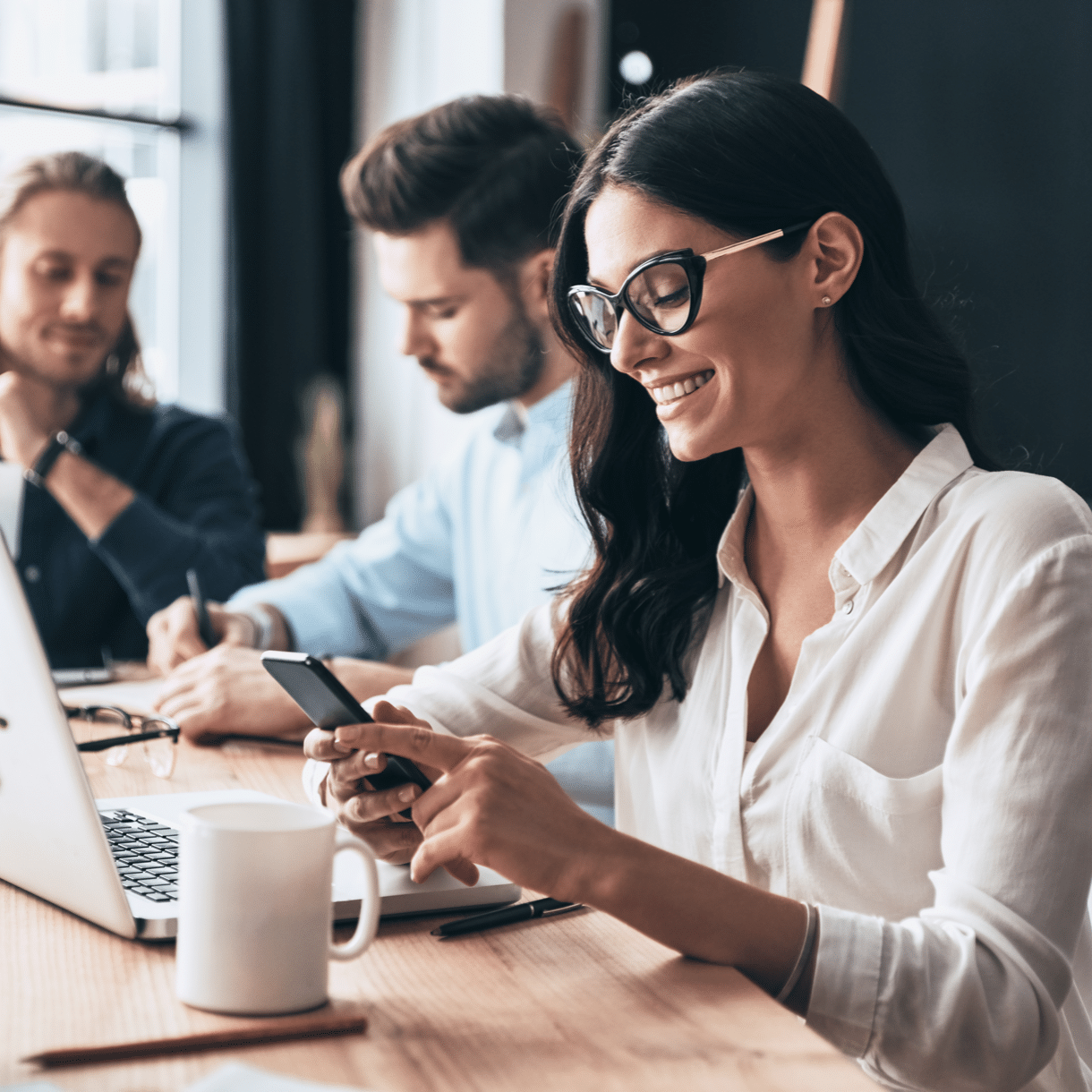 woman looking at phone in conference room